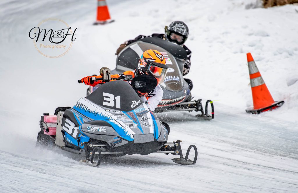 A snowmobile is being raced by Jeb Brundage. The artwork on the snowmobile was created by PTECH student Steven Hulbert.