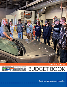The HFM Autobody instructor speaks to a group of students gathered about a car.