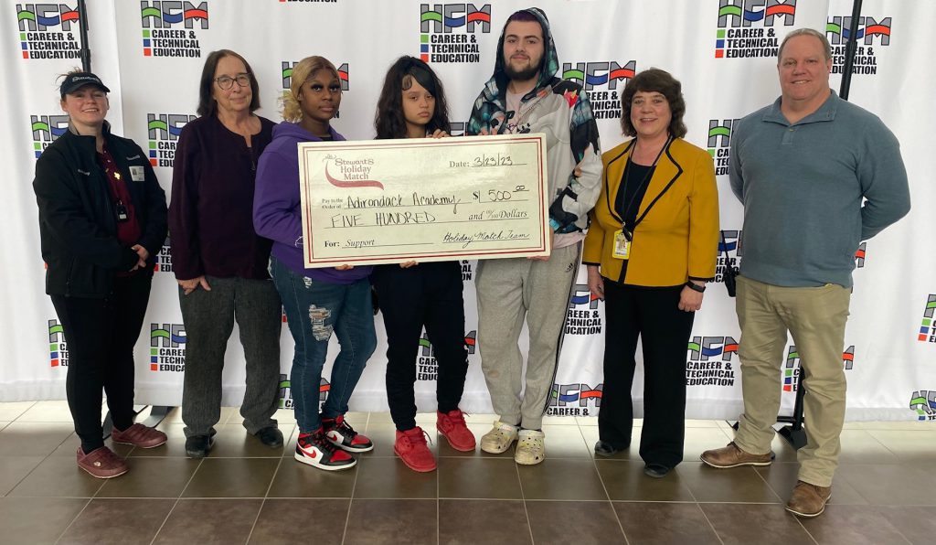 Stewart's Shops Manager Brittany DuRose at far left poses for a photo with students and staff from Adirondack Academy. DuRose presented a $500 check as part of Stewart's Shops annual Holiday Match program.