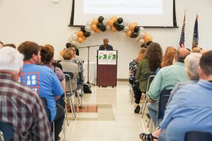 HFM PTECH Principal Celeste Keane congratulates the HFM PTECH program completers while audience members look on.