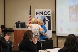 Kristi Beedon hugs Grace Frederes after presenting Frederes with the Ken Smith School Library System Regional Award.