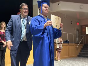 A student poses with his certificate of completion during a completion ceremony at Gloversville Middle School.