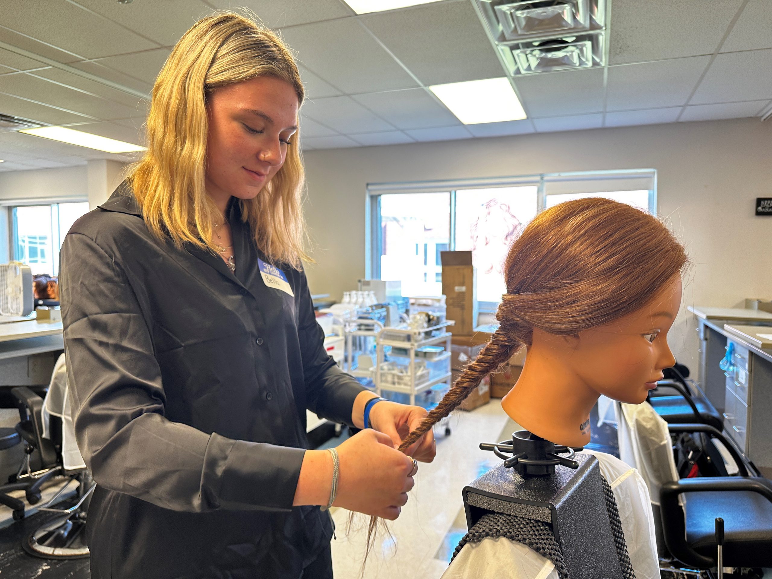 Bella Calabrese, a junior enrolled in the Cosmetology program, works on her hair styling skills at the HFM Career and Technical Education Center.